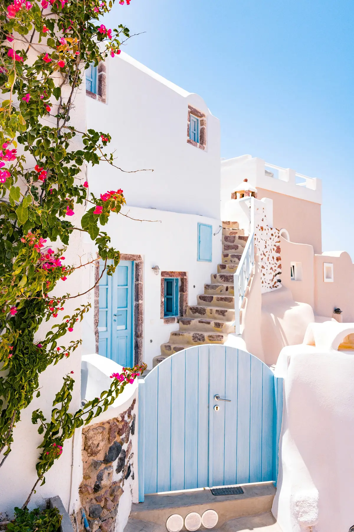 Whitewashed hotel terrace with bougainvillea in Santorini
